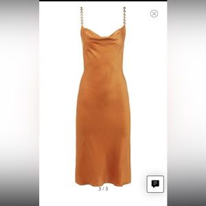 This rich satiny slipdress is styled with golden chain straps and a cowl neck.